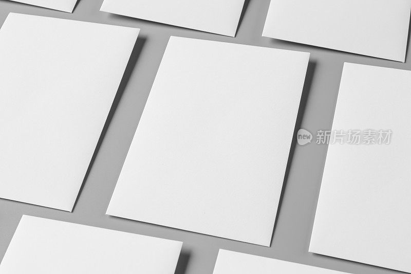 空白的肖像A4。小册子杂志孤立在灰色上，多变的背景/白纸孤立在灰色上